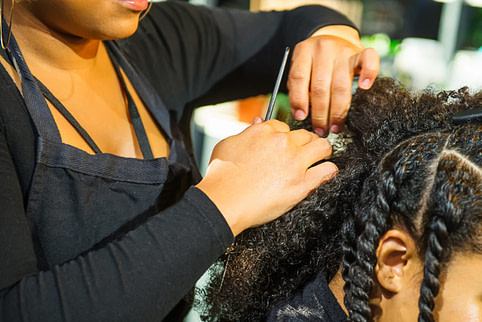 Hairstylist doing clients hair Hairstylist gain client using salon marketing strategy